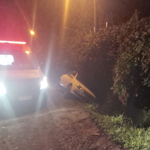 Carro cai em vala após saída de pista