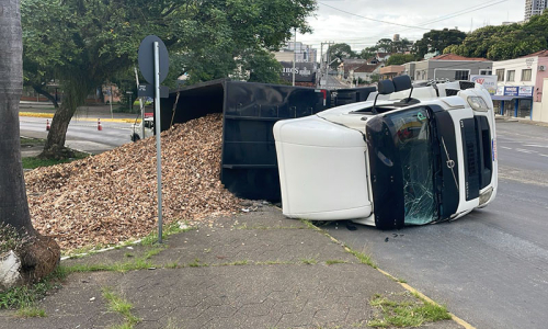 Caminhão carregado com cavacos tomba na área central