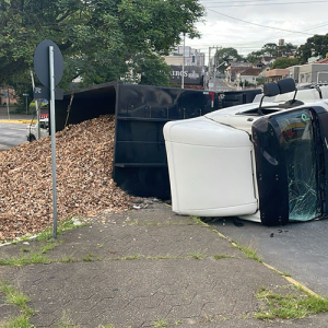 Caminhão carregado com cavacos tomba na área central
